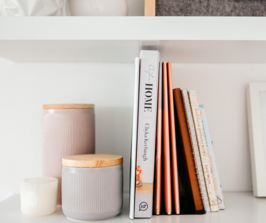 Image of candles and books aesthetically placed on shelf